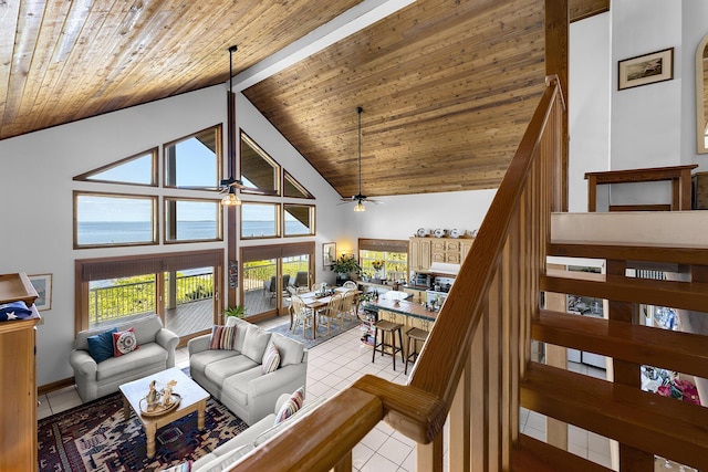 tiled living room with wood ceiling, ceiling fan, high vaulted ceiling, a water view, and beamed ceiling