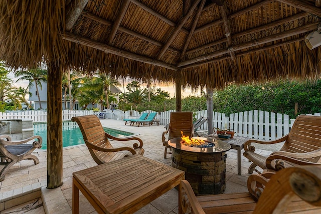 view of patio / terrace with a fenced in pool, a fire pit, and a gazebo