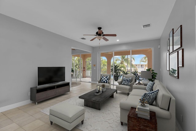 living room featuring baseboards, a ceiling fan, visible vents, and light tile patterned floors