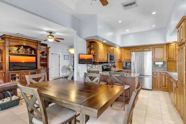 tiled dining room featuring a towering ceiling and ceiling fan