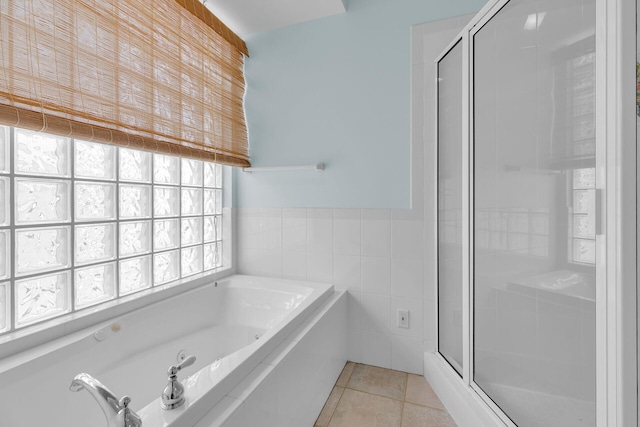 bathroom featuring a bath, tile walls, tile patterned flooring, and a shower stall