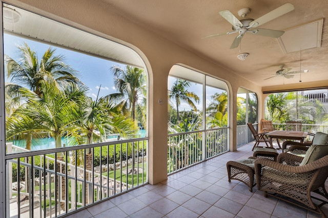 sunroom / solarium featuring a water view, ceiling fan, and a healthy amount of sunlight