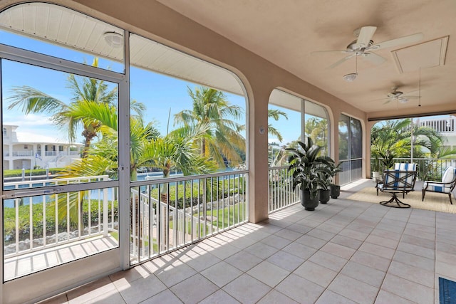 unfurnished sunroom with tile patterned floors and a water view