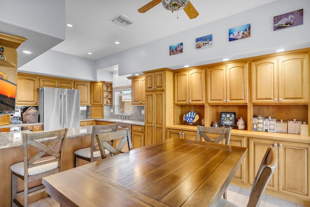 tiled dining space with ceiling fan