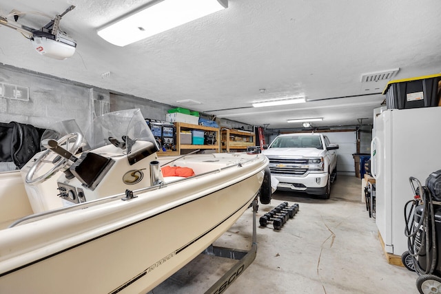 garage with white refrigerator and a garage door opener