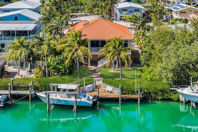 dock area with stairway, a yard, boat lift, and a water view