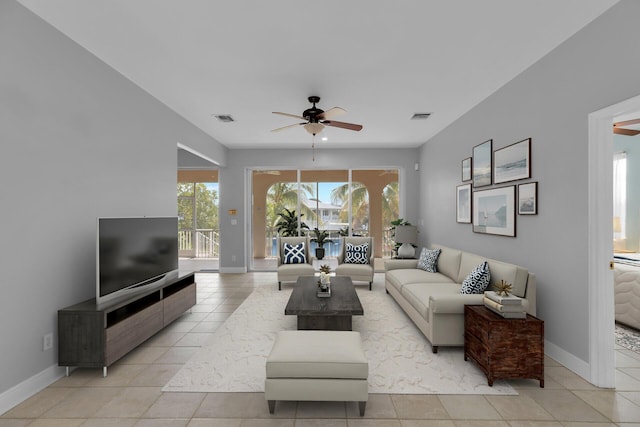 living area with visible vents, a ceiling fan, baseboards, and light tile patterned floors