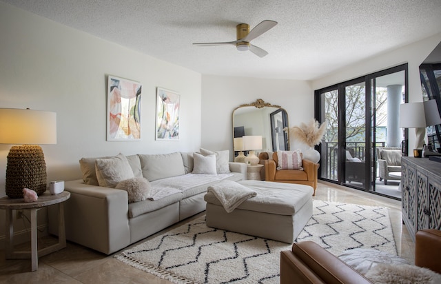 living room with ceiling fan and a textured ceiling