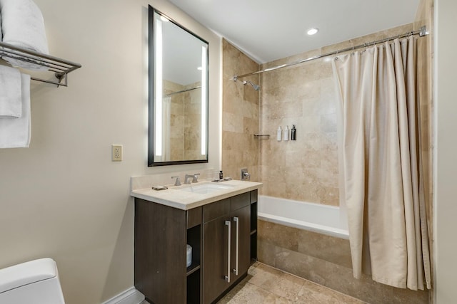 bathroom with toilet, tiled shower / bath, and vanity