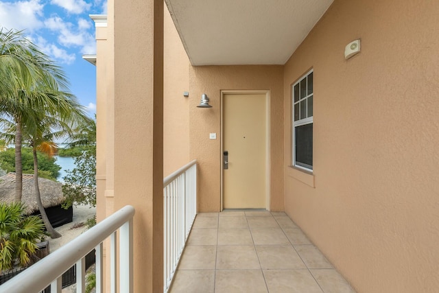 view of exterior entry featuring a balcony and stucco siding