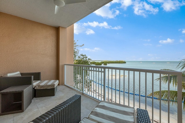 balcony featuring a water view, ceiling fan, and a view of the beach