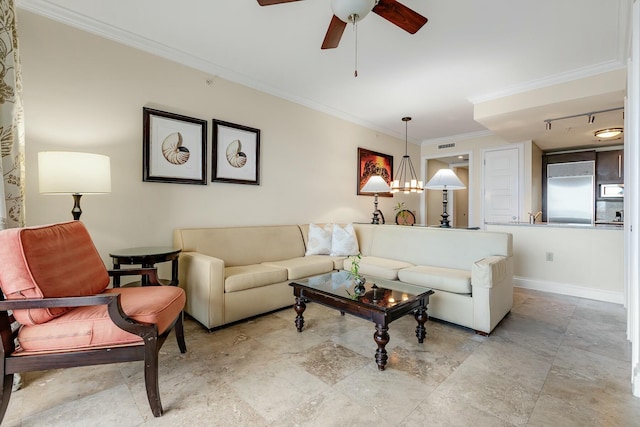 living room with ornamental molding, baseboards, and ceiling fan with notable chandelier