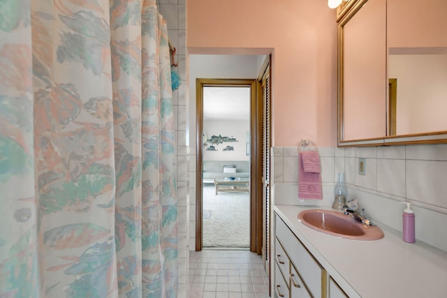 bathroom featuring vanity, tile patterned flooring, tile walls, and walk in shower