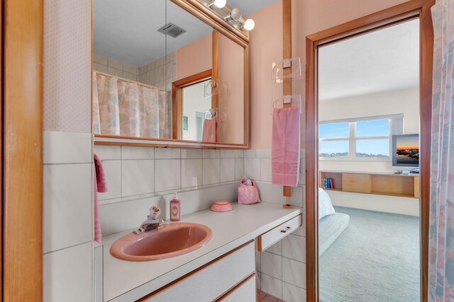 bathroom with vanity, tile walls, and walk in shower