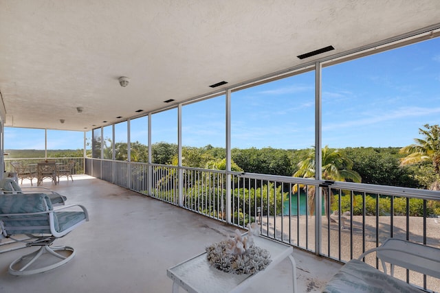 sunroom / solarium featuring a water view