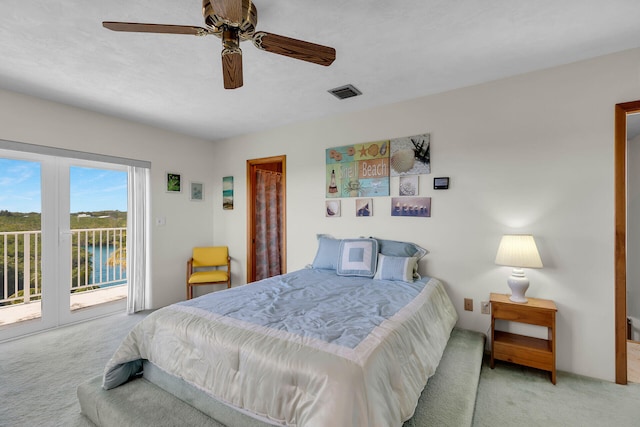 carpeted bedroom with a water view, access to exterior, and ceiling fan