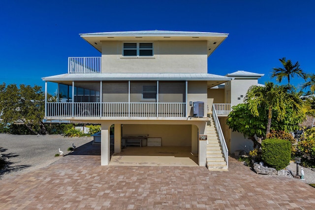 view of front of property with cooling unit, a garage, a sunroom, and a carport