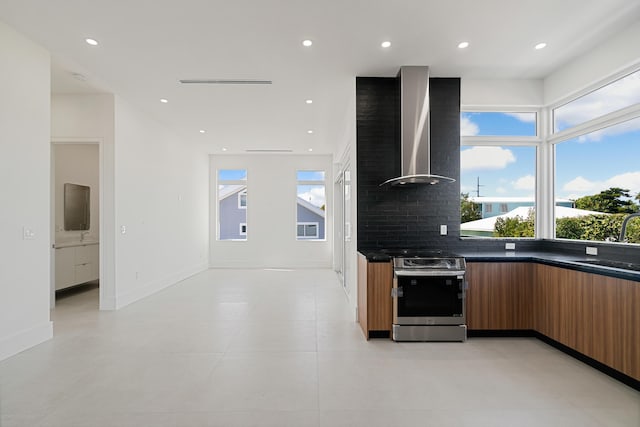 kitchen with sink, wall chimney range hood, stainless steel range with electric cooktop, and decorative backsplash