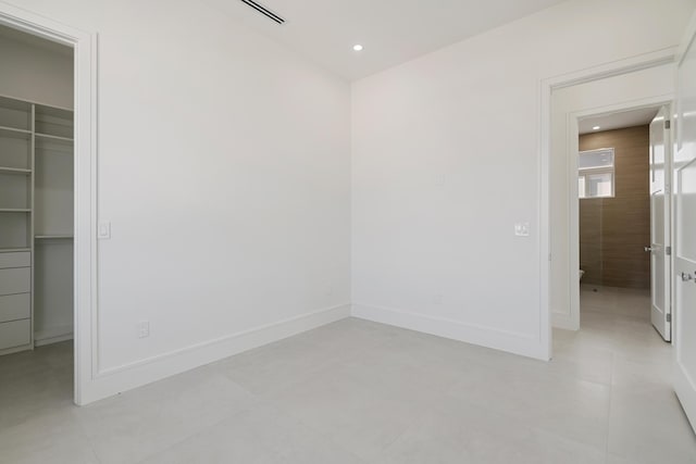 unfurnished bedroom with a walk in closet and a closet