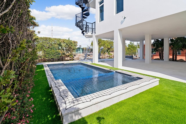 view of swimming pool featuring a yard and a patio