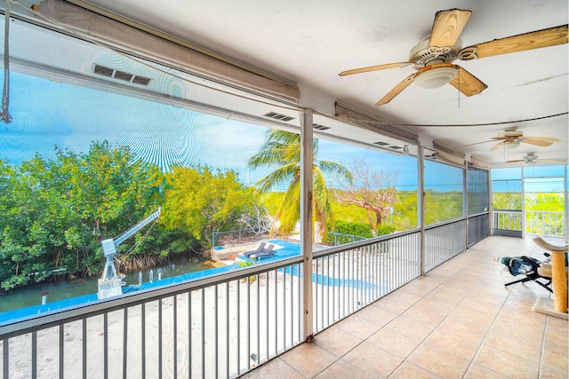 unfurnished sunroom featuring ceiling fan