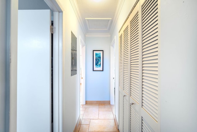 corridor featuring baseboards, stone tile floors, attic access, and crown molding