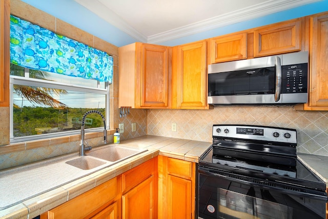 kitchen with black electric range, stainless steel microwave, a sink, and tile countertops