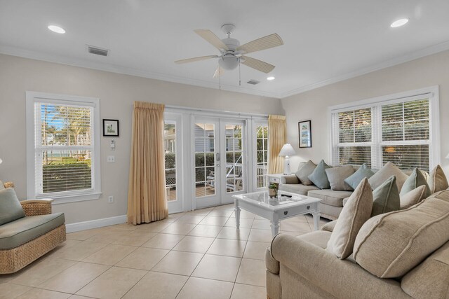 tiled living room featuring crown molding, a healthy amount of sunlight, and french doors