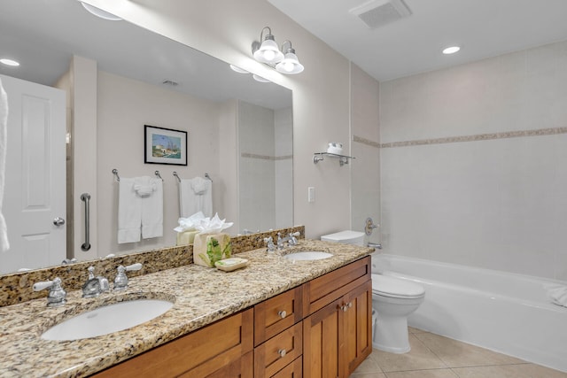 full bathroom with tile patterned flooring, vanity, tiled shower / bath combo, and toilet