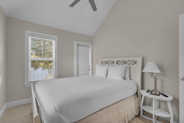 bedroom with lofted ceiling, ceiling fan, and light tile patterned flooring