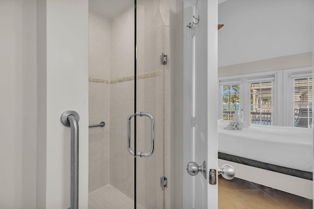 bathroom with tile patterned floors and a shower with door