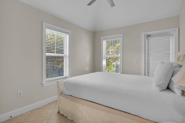 bedroom featuring lofted ceiling, light tile patterned floors, and ceiling fan