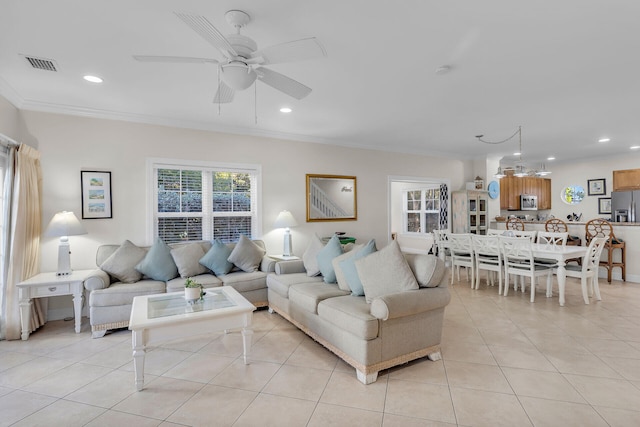 tiled living room with crown molding and ceiling fan