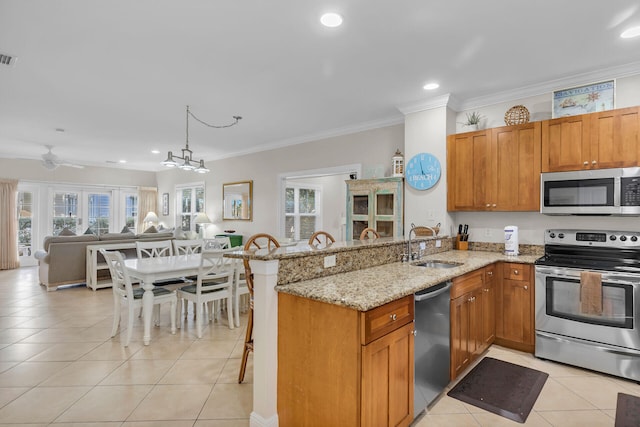 kitchen with appliances with stainless steel finishes, sink, light tile patterned floors, kitchen peninsula, and light stone countertops