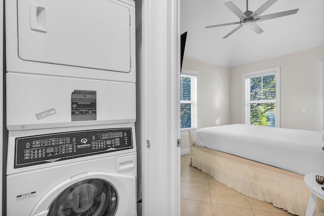 clothes washing area with ceiling fan, light tile patterned flooring, a healthy amount of sunlight, and stacked washer / dryer