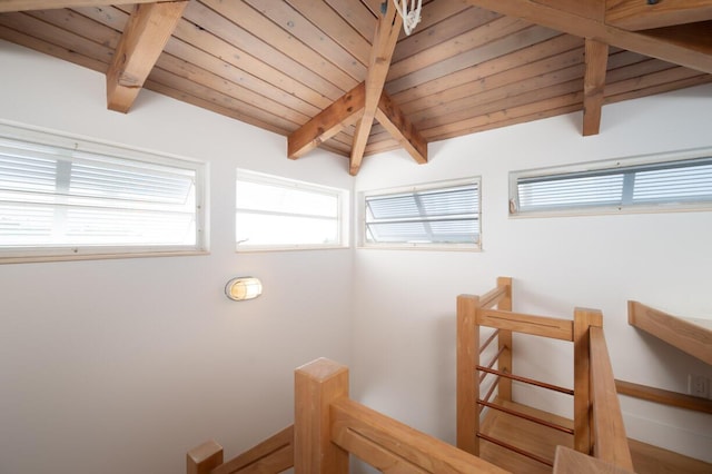 stairway featuring lofted ceiling with beams and wooden ceiling