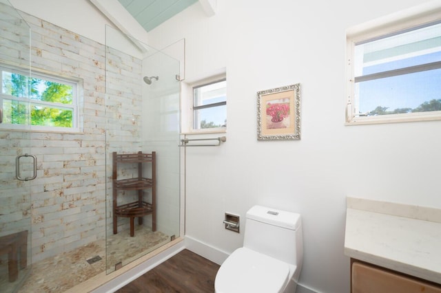 bathroom featuring hardwood / wood-style flooring, a shower with shower door, and toilet