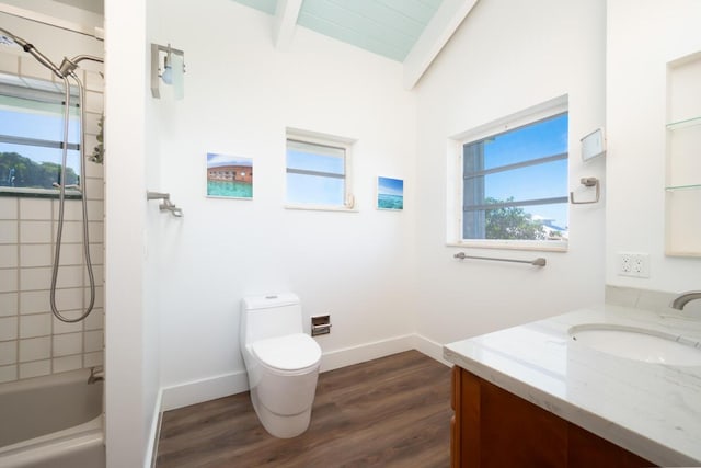 full bathroom featuring toilet, tiled shower / bath, wood-type flooring, lofted ceiling with beams, and vanity