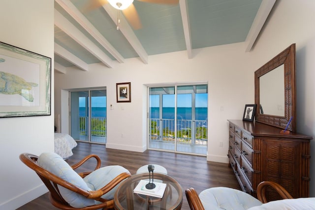 sitting room featuring a water view, dark wood-type flooring, and lofted ceiling with beams