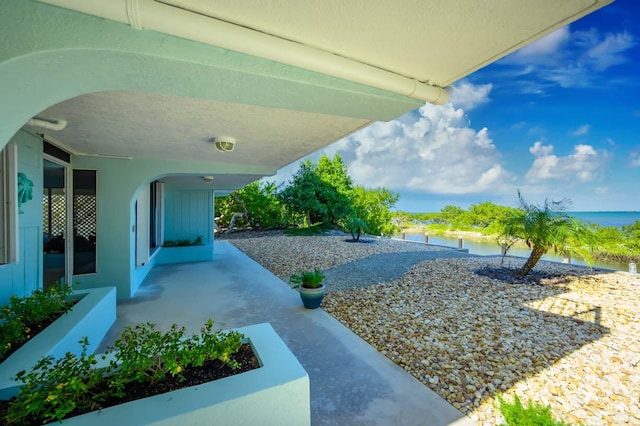 view of yard featuring a water view and a patio area