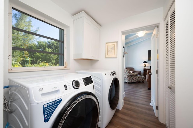 washroom featuring dark hardwood / wood-style floors, washing machine and dryer, and cabinets