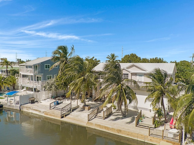 dock area with a water view and a balcony