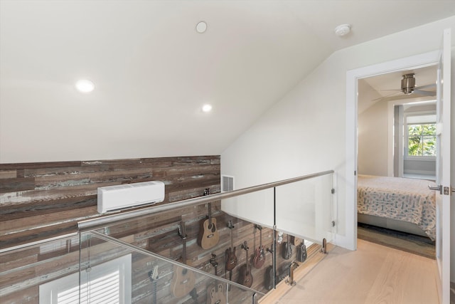 corridor with lofted ceiling and light hardwood / wood-style floors