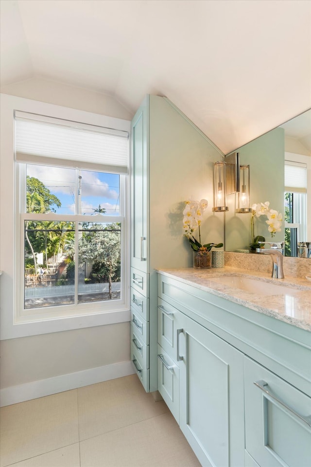 bathroom featuring vanity, lofted ceiling, and tile patterned floors