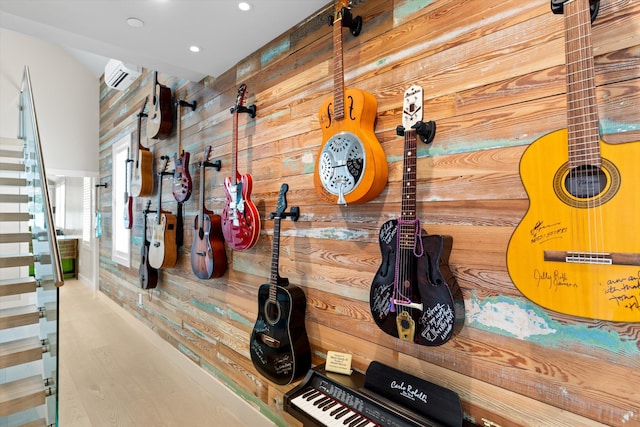 miscellaneous room with an AC wall unit, hardwood / wood-style floors, and wood walls