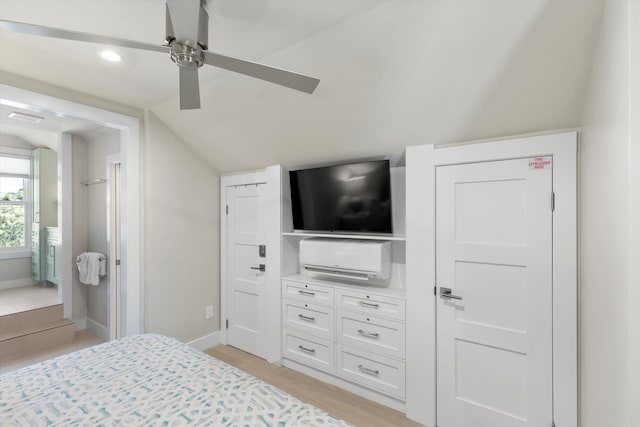 bedroom with ceiling fan, ensuite bath, lofted ceiling, and light wood-type flooring