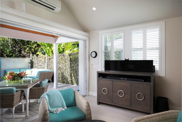 living room with lofted ceiling and a wall mounted air conditioner