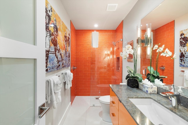 bathroom with vanity, tile patterned floors, toilet, and tiled shower