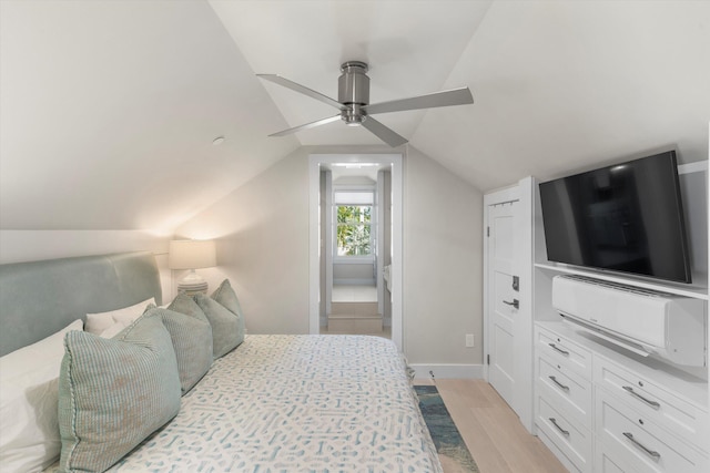 bedroom with ceiling fan, vaulted ceiling, and light hardwood / wood-style flooring