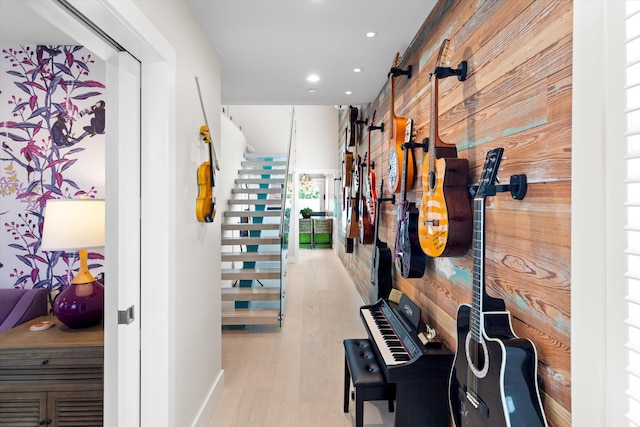 hall featuring light hardwood / wood-style floors and wood walls